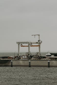 Industrial cargo crane at St. Petersburg harbor under cloudy skies, ideal for transportation themes.