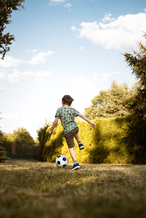 Photo En Contre Plongée D'un Garçon Jouant Au Football