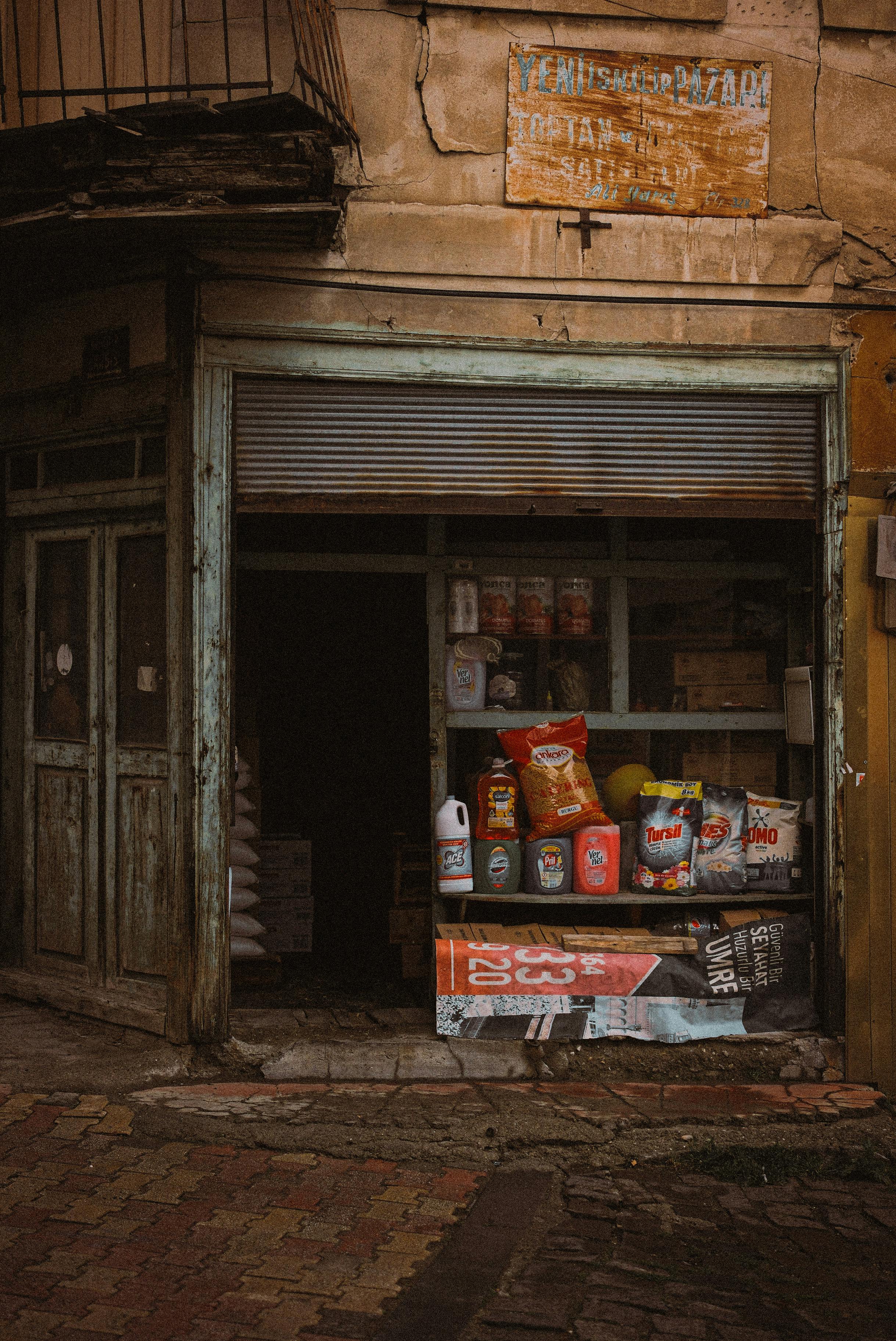 A vintage-style urban storefront displaying various goods in muted colors, exuding a rustic charm.
