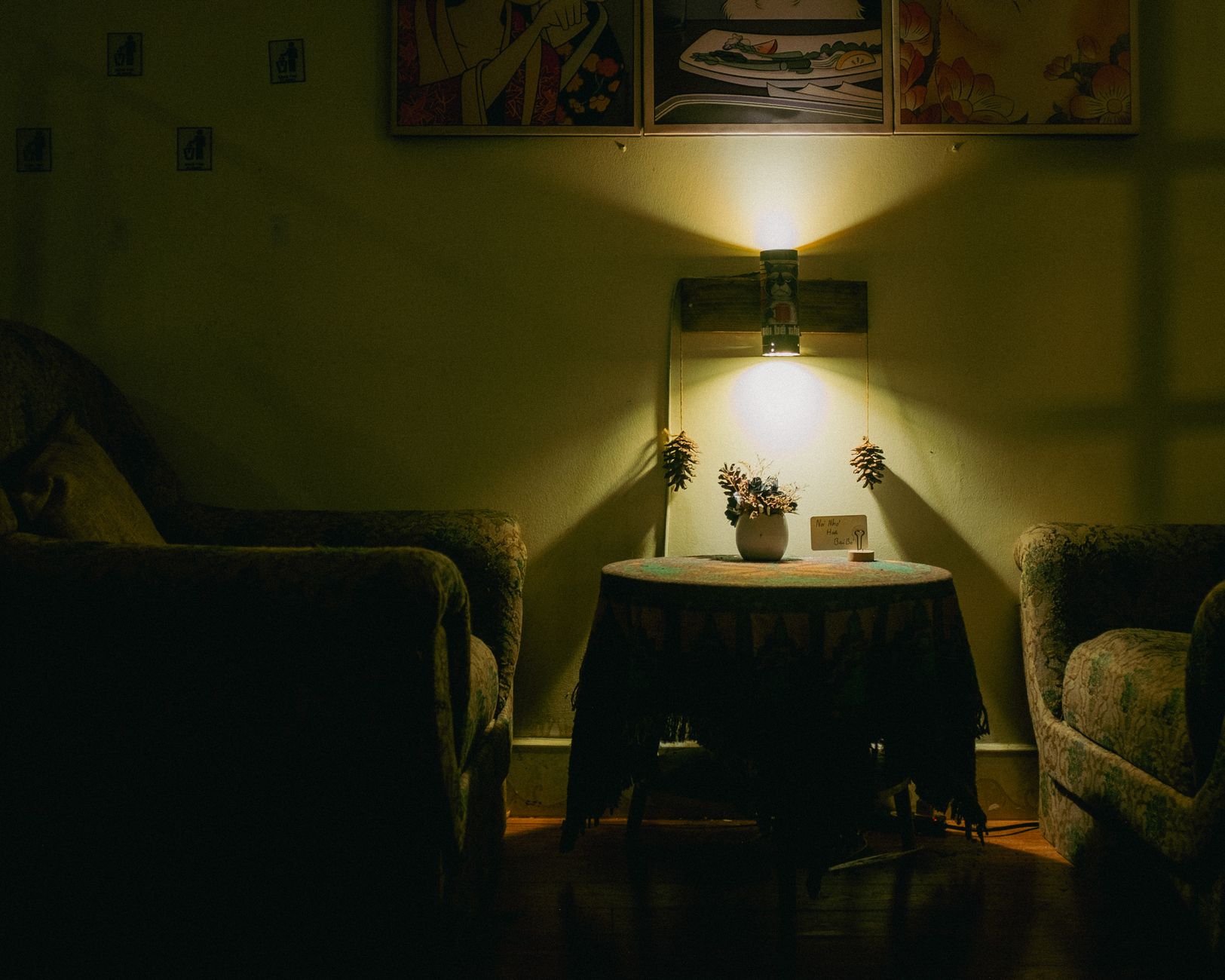 A warmly lit living room showcasing armchairs, a table, and soft lighting for a cozy ambiance.