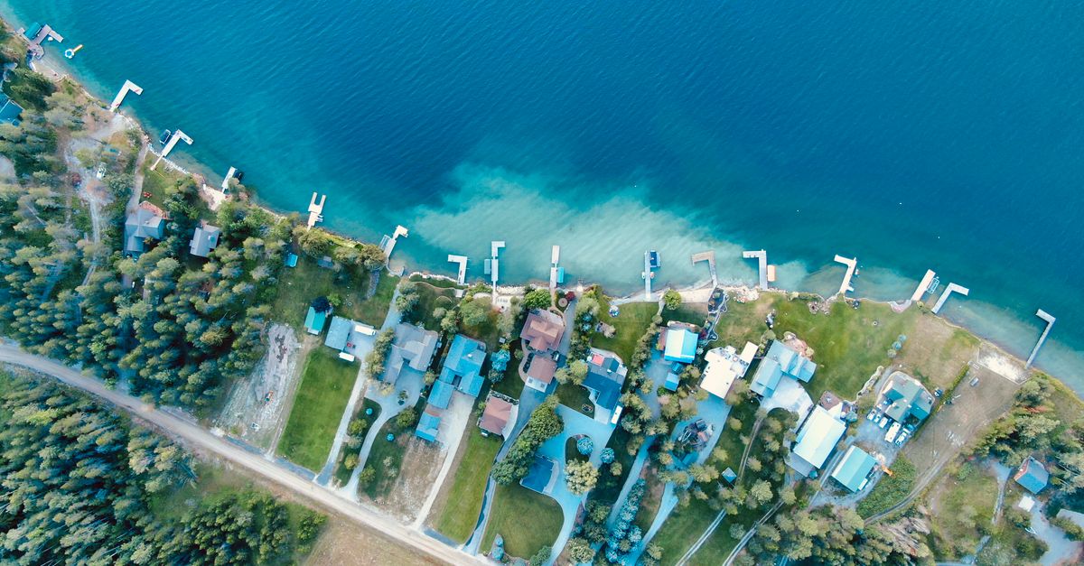Drone shot of scenic lakefront homes in Priest River, Idaho, showcasing dock and waterfront vistas.