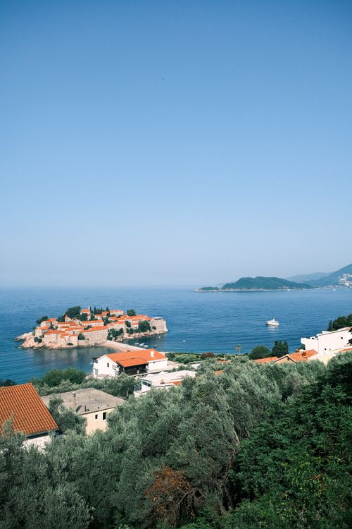 Free Captivating aerial view of the scenic Sveti Stefan coastline, showcasing the charming island and vibrant blue sea. Stock Photo