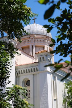 View of Ada Yani Church dome framed by lush trees on Burgazada island, Istanbul.