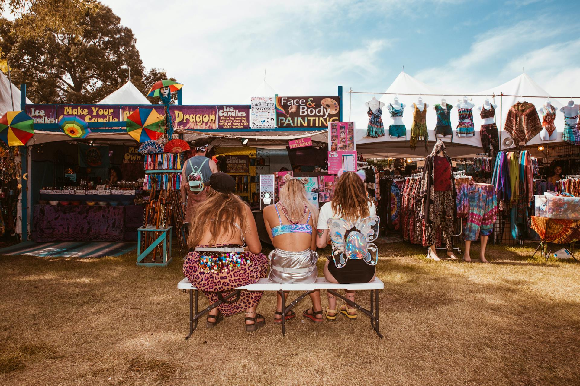 Bright festival scene featuring carnival booths and stylishly dressed women enjoying a sunny day.