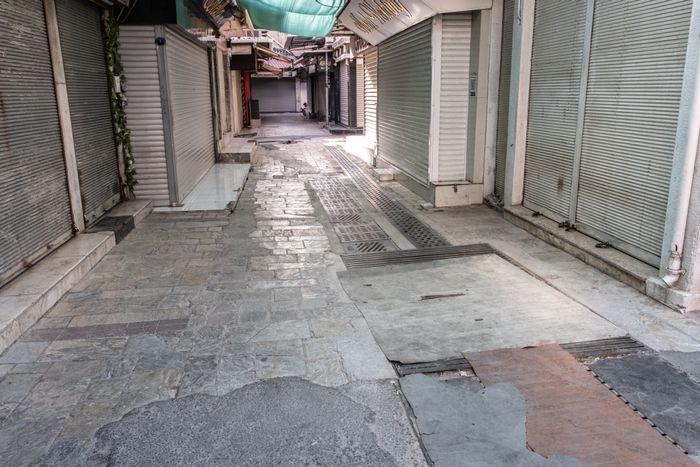 A deserted alley of shuttered shopfronts — photo by Doğan Alpaslan Demir on Pexels