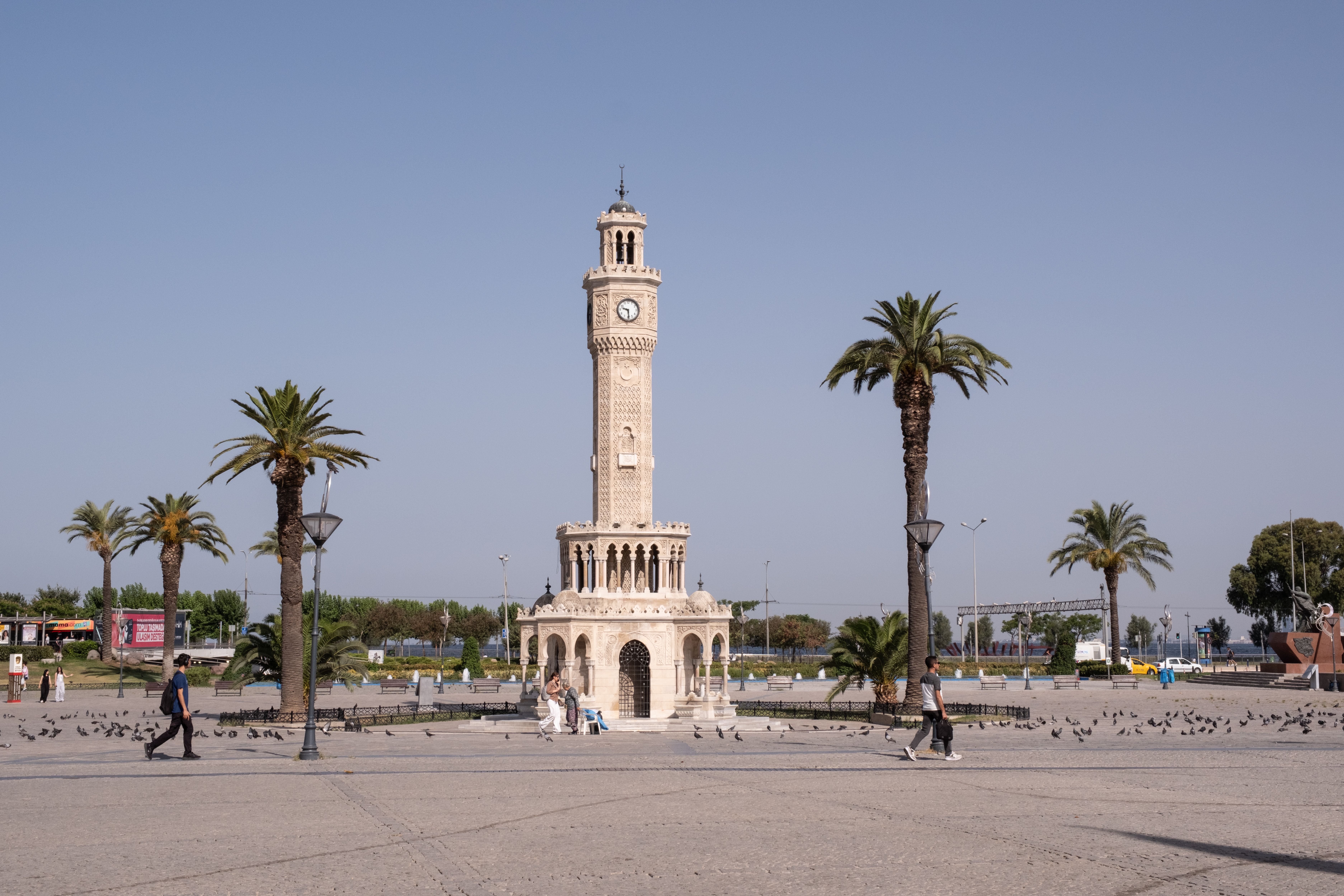 Ornate Ottoman clock tower in Konak Square at golden hour, İzmir, Turkey, Aegean waterfront with bustling city life backdrop