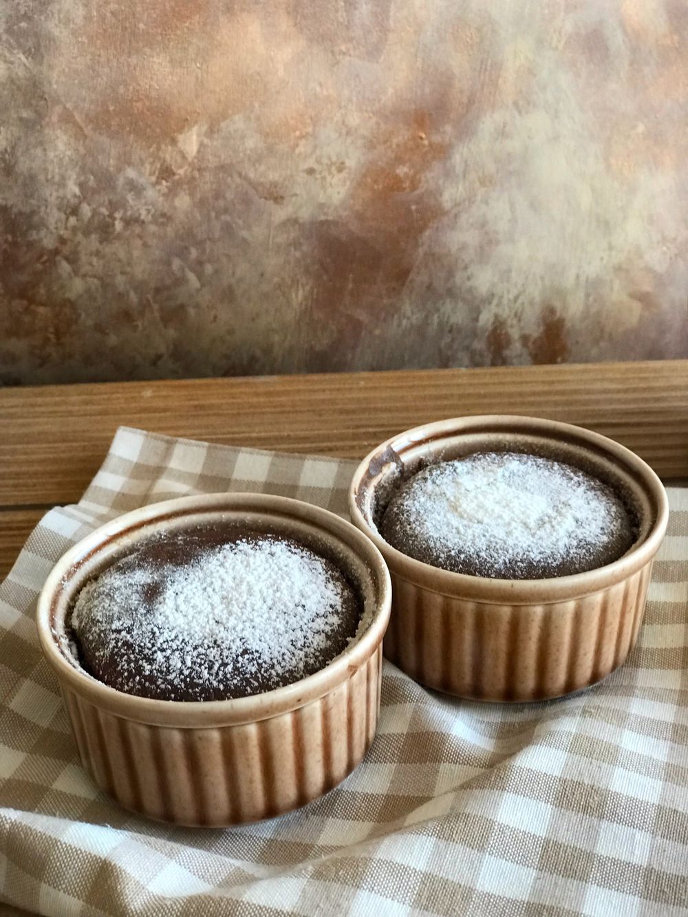 Two chocolate souffles dusted with sugar in ceramic ramekins — photo by Melda Besir on Pexels
