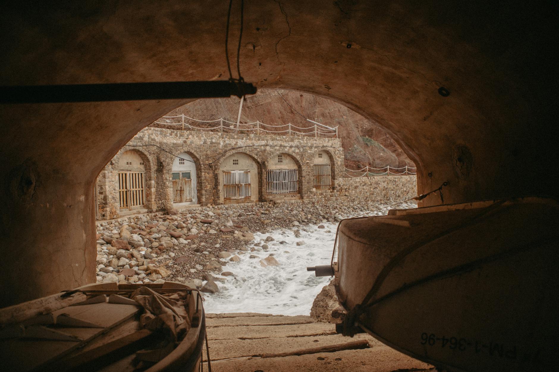 A scenic view of a stone fisherman's cave by the sea in Deià, Spain.