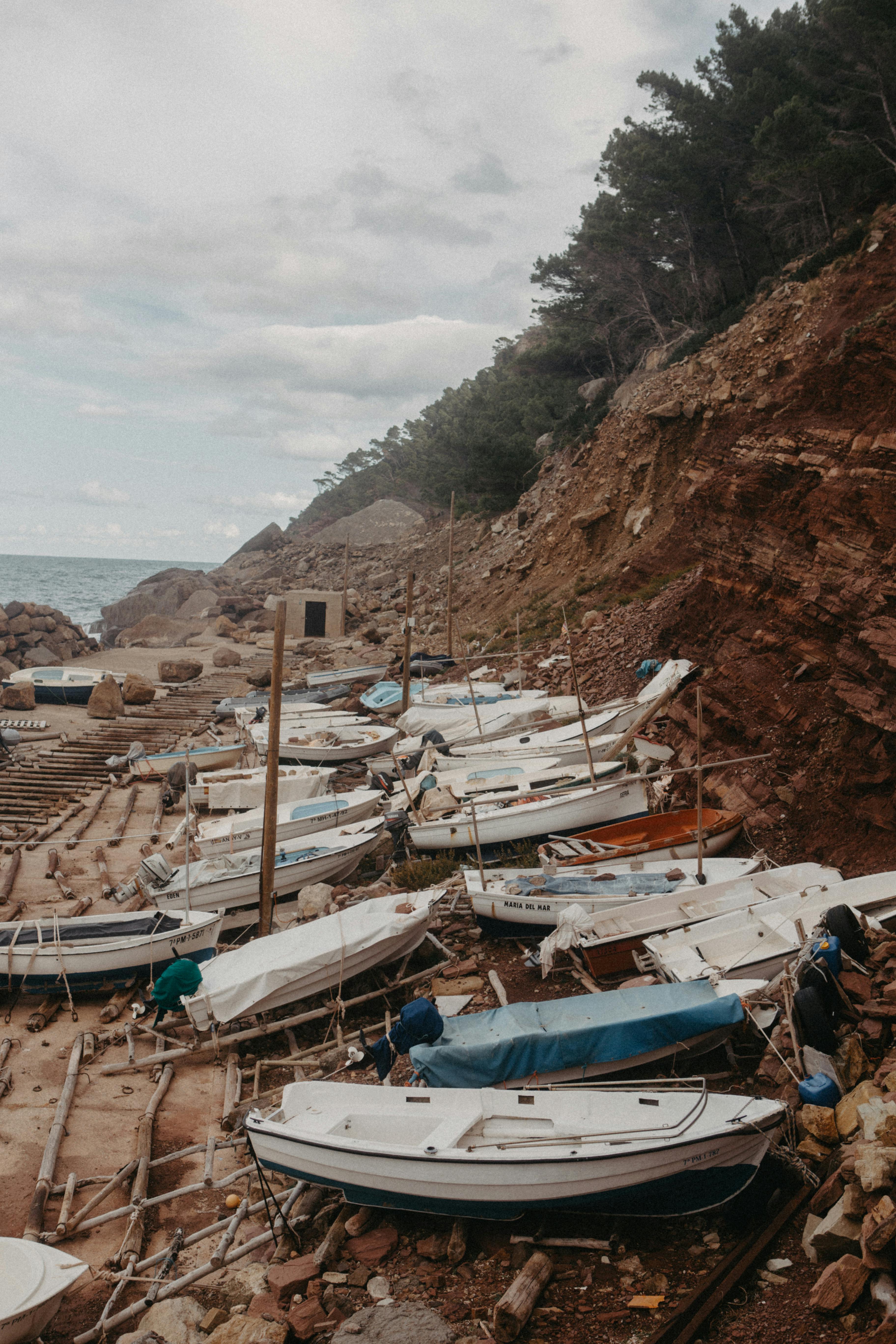 Scenic view of boats on the rocky coast of Deià, a picturesque village in Spain.