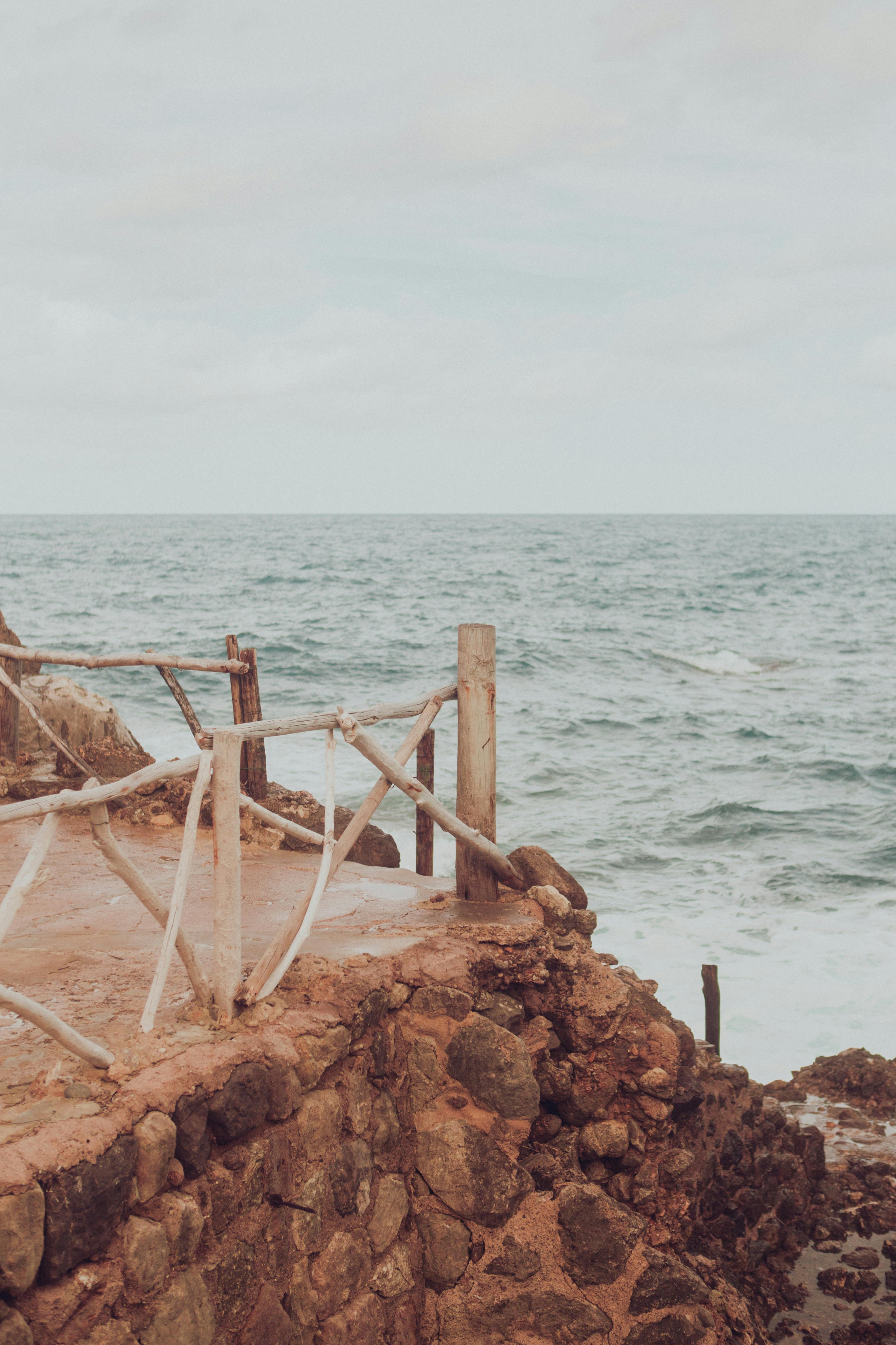 Rustic lookout over the ocean in Palma, Spain with cloudy skies and rugged shoreline.