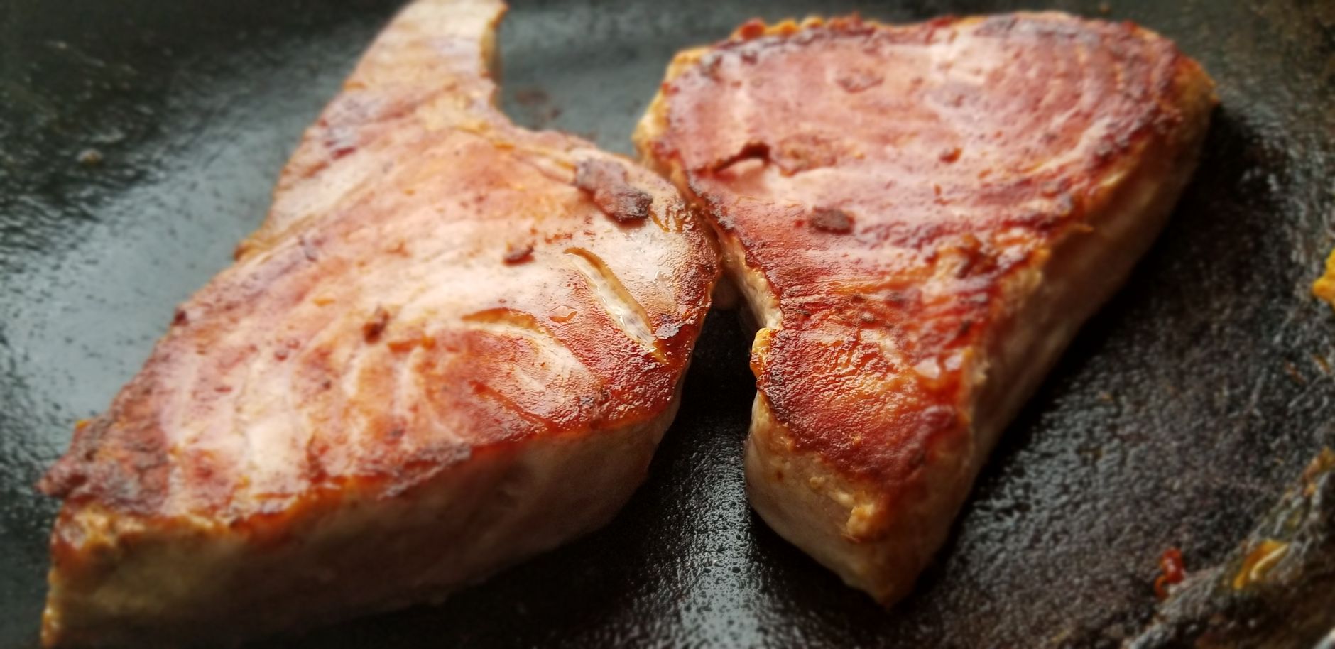Cooking tuna steak in hot cast iron skillet with oil and butter