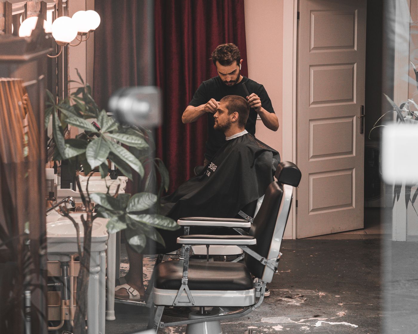 Barber styling a client's hair in a modern barbershop
