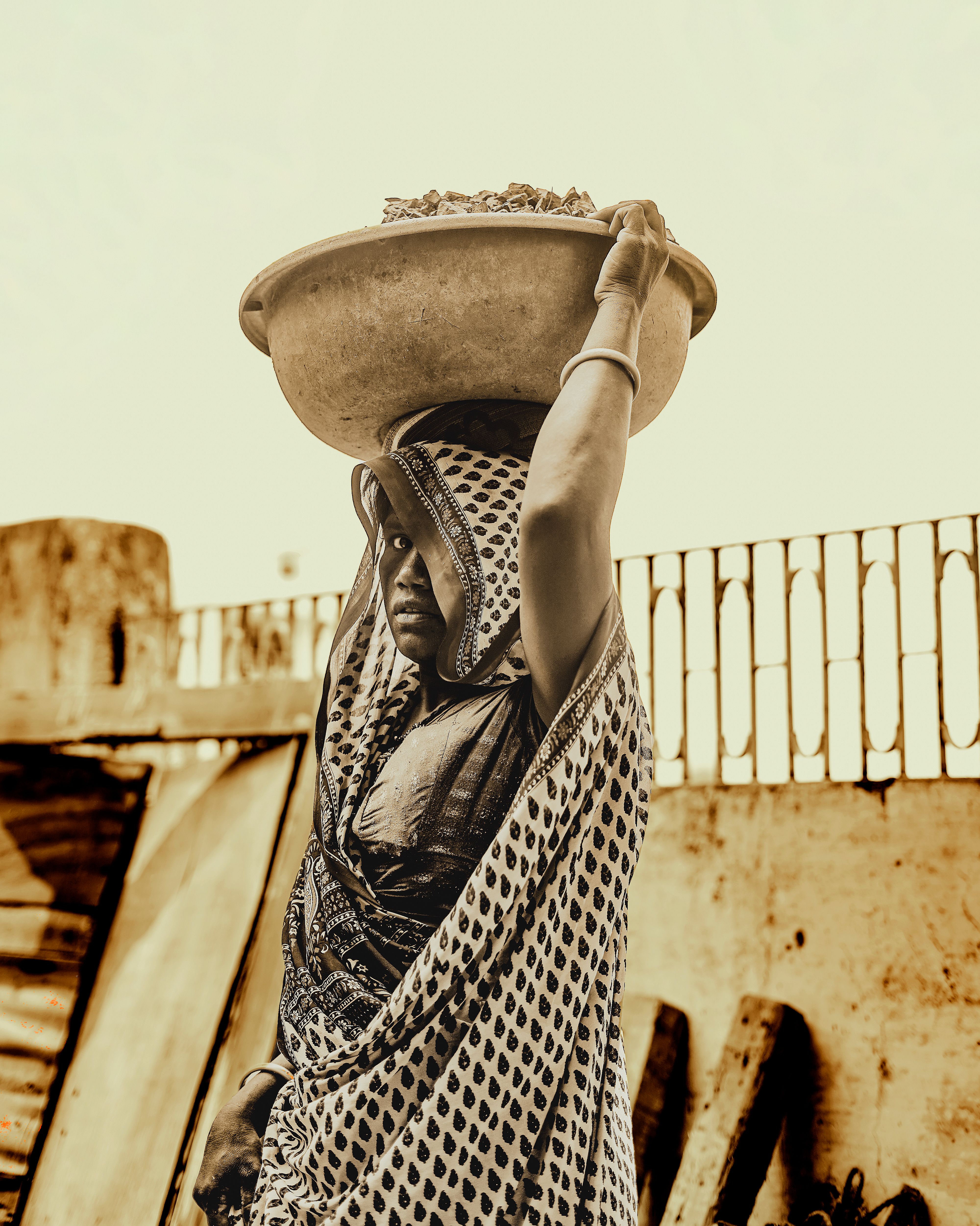 Candid shot of a woman carrying a bowl on her head in Ahmedabad, India. | Indian Village Development