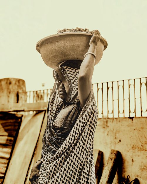 Free Candid shot of a woman carrying a bowl on her head in Ahmedabad, India. Stock Photo
