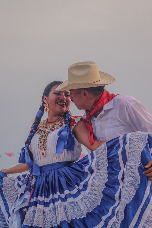 Free Couple in traditional dress performing a folk dance outdoors with joyful expressions. Stock Photo