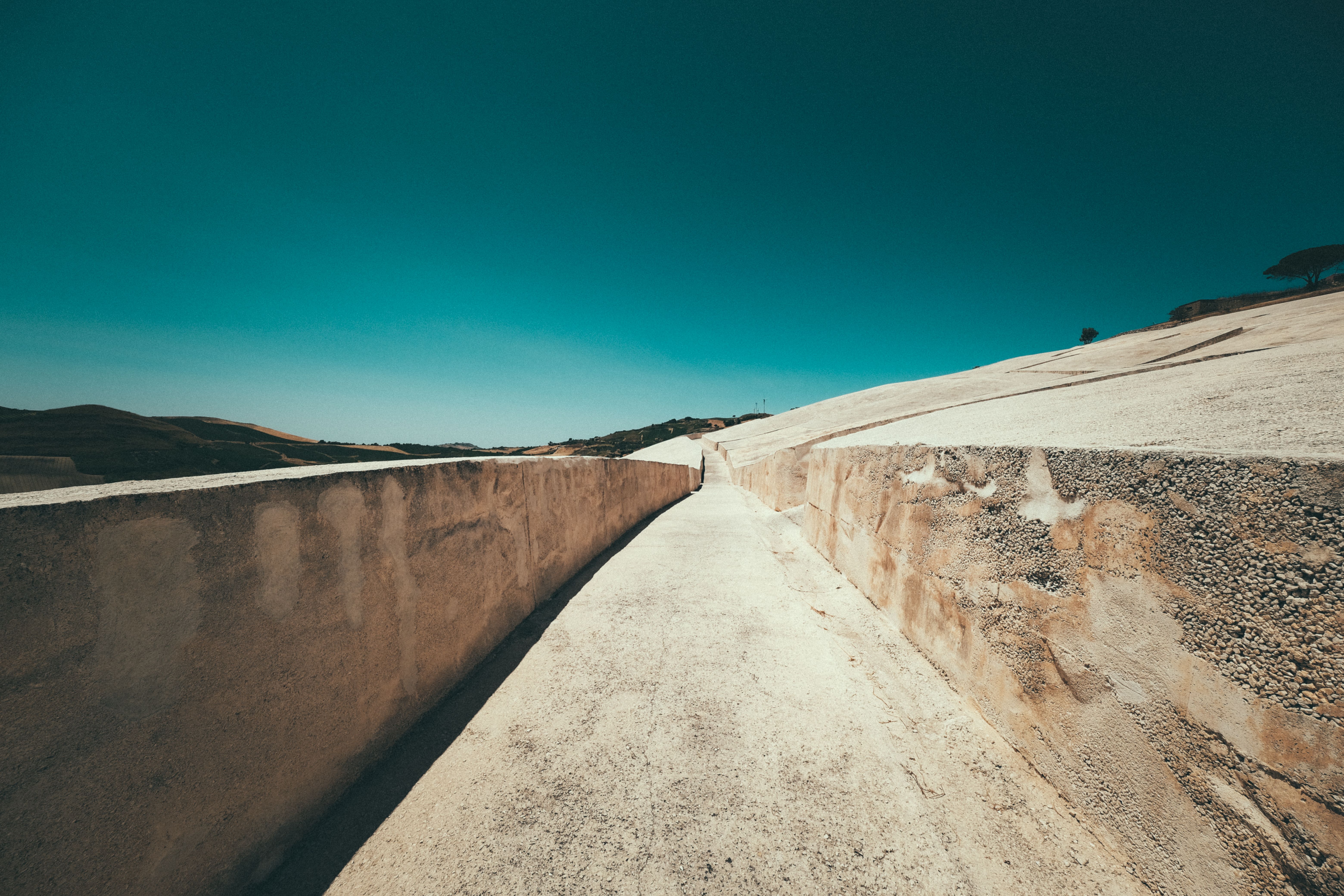 A striking view of the Grande Cretto, a large-scale artwork by Alberto Burri in Gibellina, Sicily under a clear blue sky.
