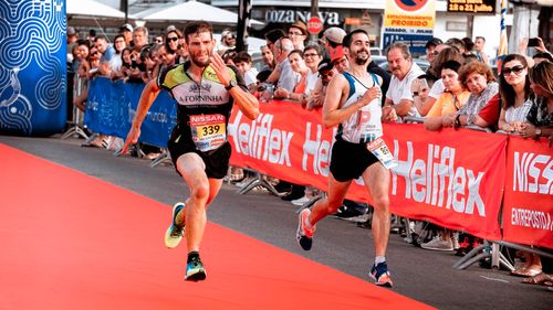 Free Two marathon runners sprint towards the finish line amid a cheering crowd during a race. Stock Photo