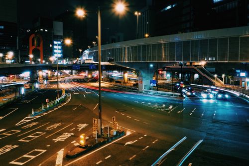 Free Vibrant night view of Tokyo city streets with glowing traffic lights and elevated walkways. Stock Photo
