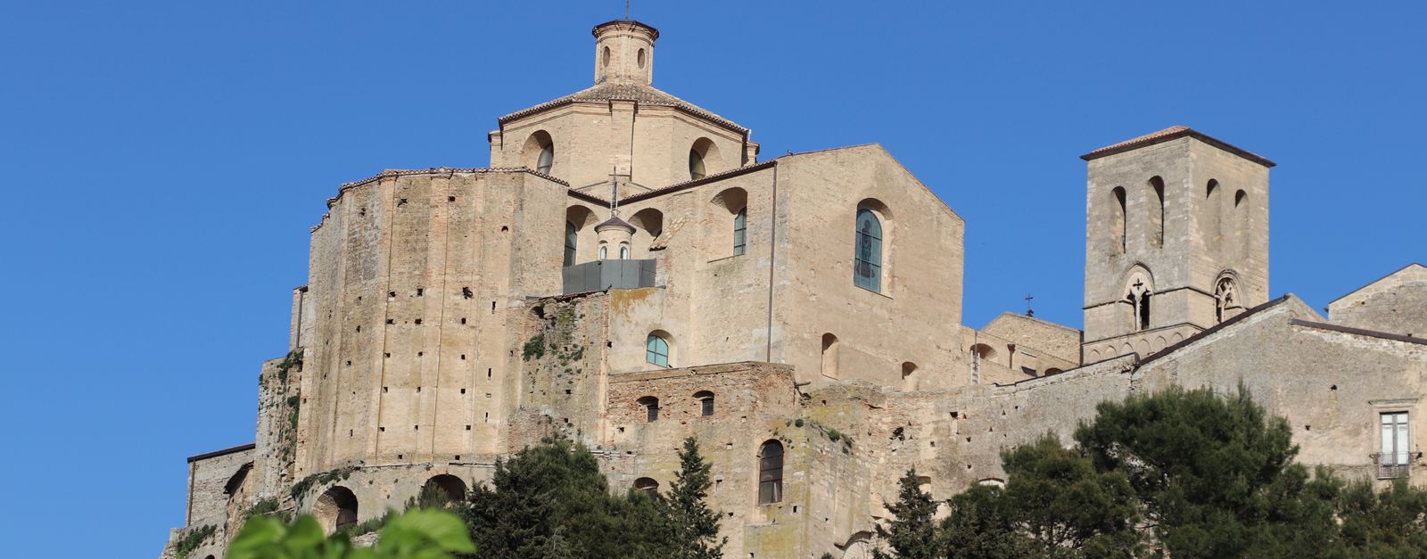 View of ancient abbey against bright blue sky, showcasing architectural details.
