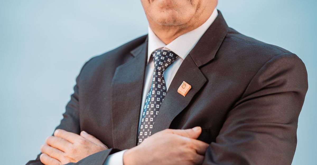 Photo by Bhandari Law and Partners Portrait of a confident businessman wearing a formal suit against a blue background.