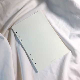 Dotted notebook page on soft white fabric — photo by Phuong Tran on Pexels