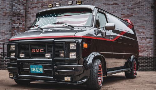 Free Classic GMC Vandura van featuring retro design and American flag details on the windshield. Stock Photo