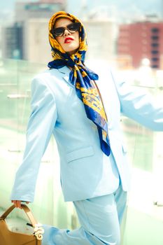 Stylish woman in blue suit and headscarf posing outdoors in Mexico City.