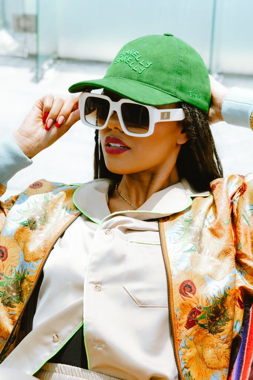 Free Chic woman in a green cap and sunglasses, enjoying the sun in Mexico City. Stock Photo