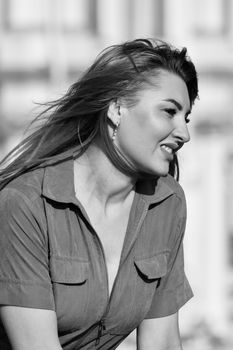 Stylish black and white side view portrait of a woman with a windy hair effect.