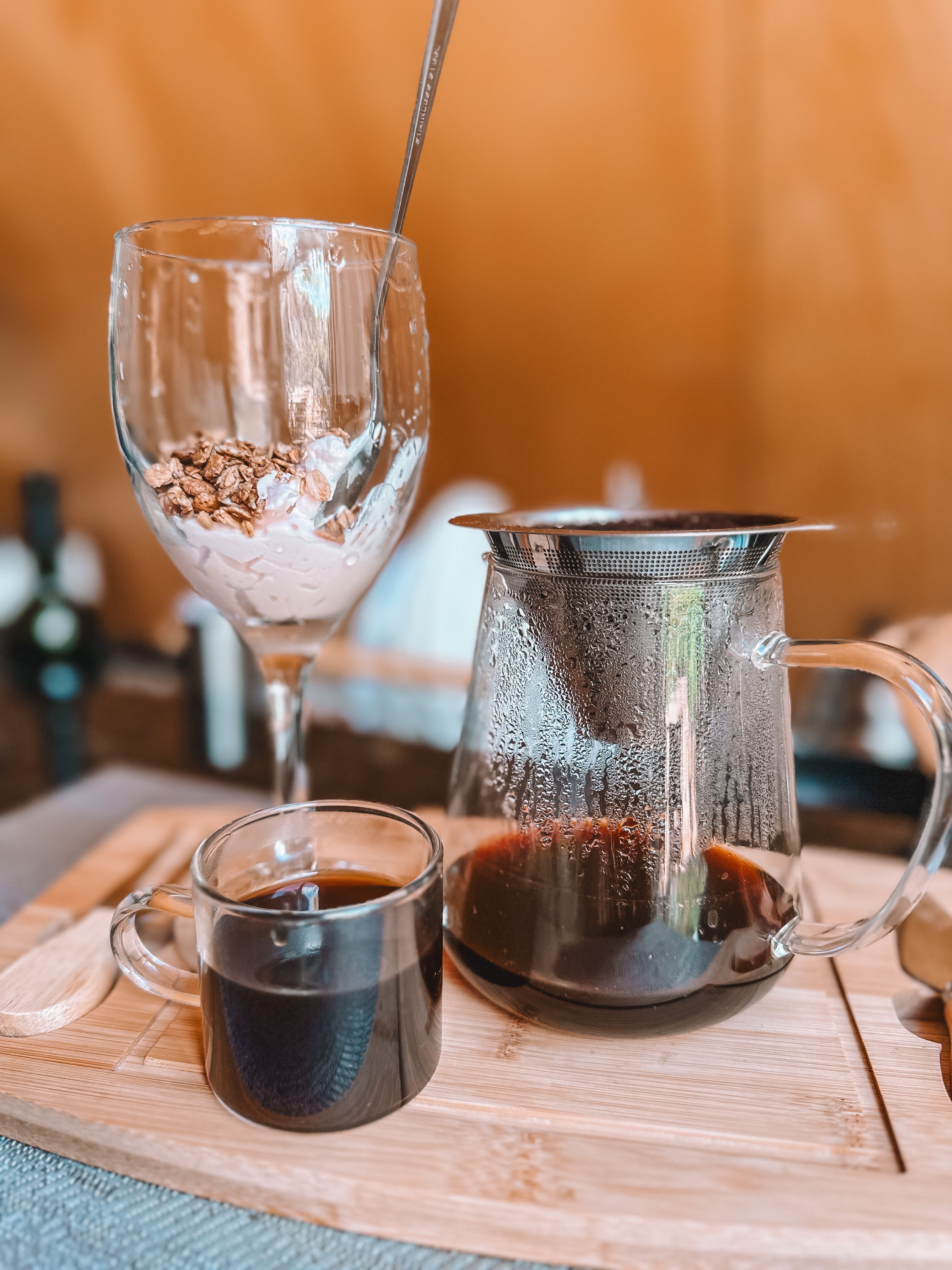 Glass of Coffee next to Drip Coffee Maker and Muesli in Wine Glass on ...