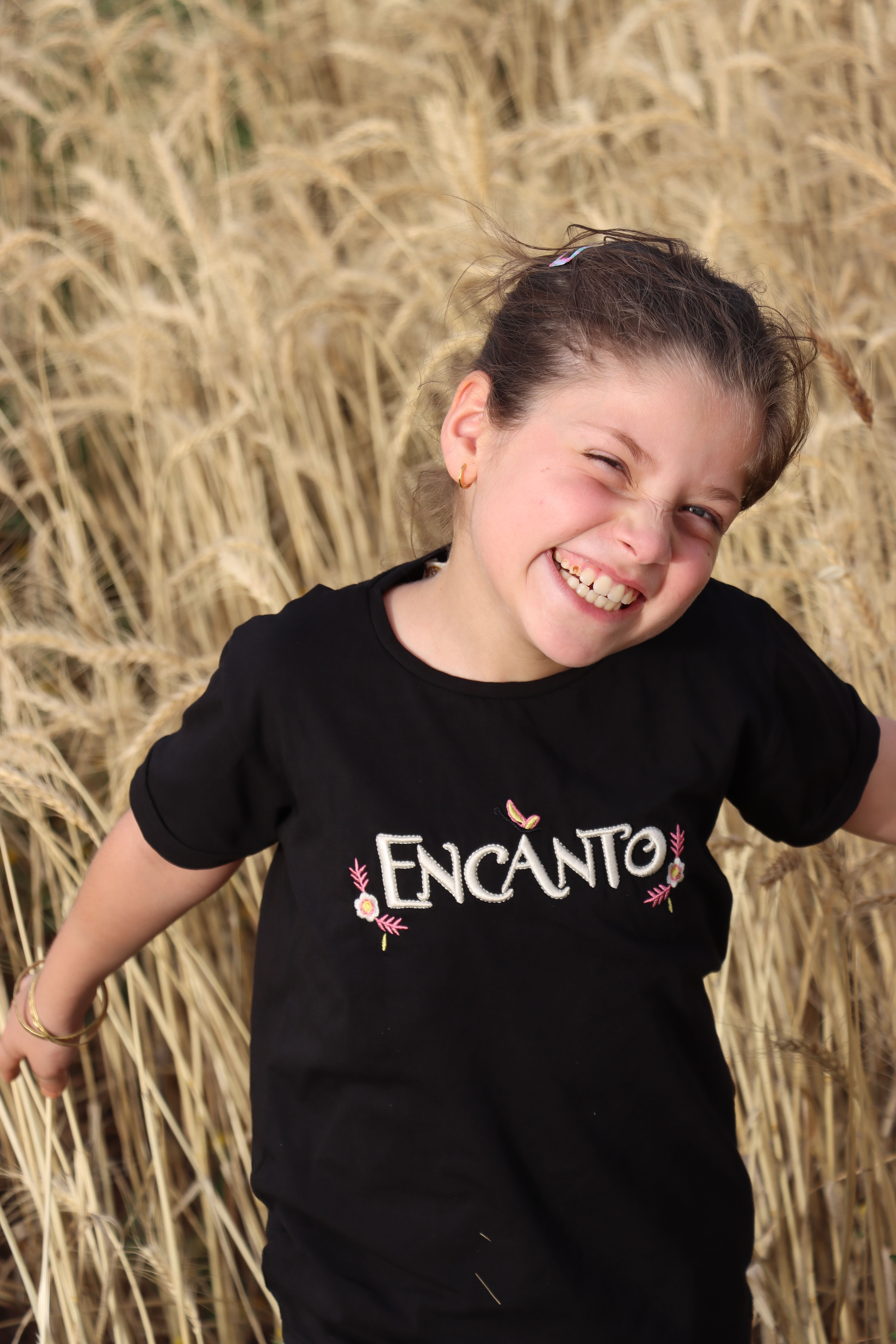 A little girl smiling in a field of wheat · Free Stock Photo