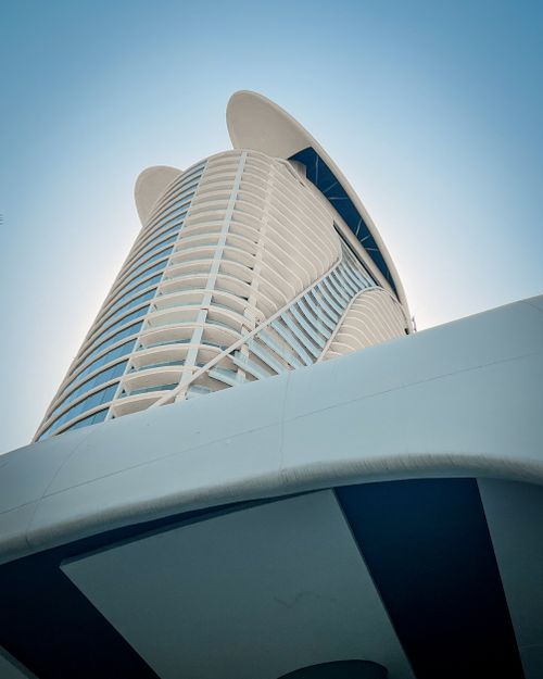 Free Low-angle view of a modern skyscraper with sleek design under a clear blue sky. Stock Photo