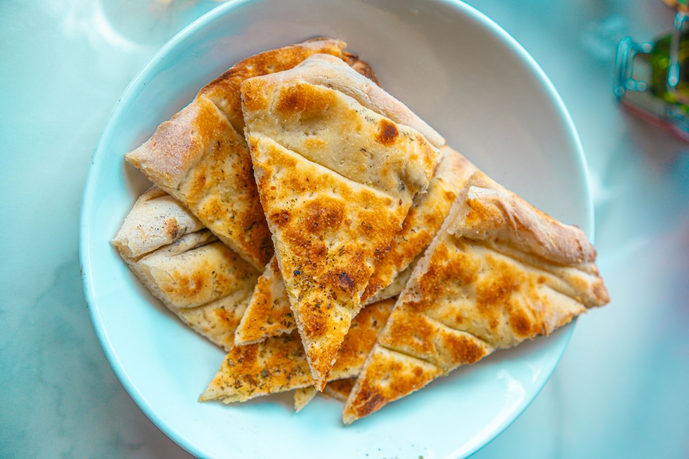 Crispy homemade garlic bread slices served on a white plate, perfect for sharing.