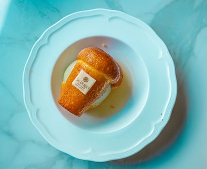 A scrumptious rum baba dessert elegantly served on a white plate in close-up view.