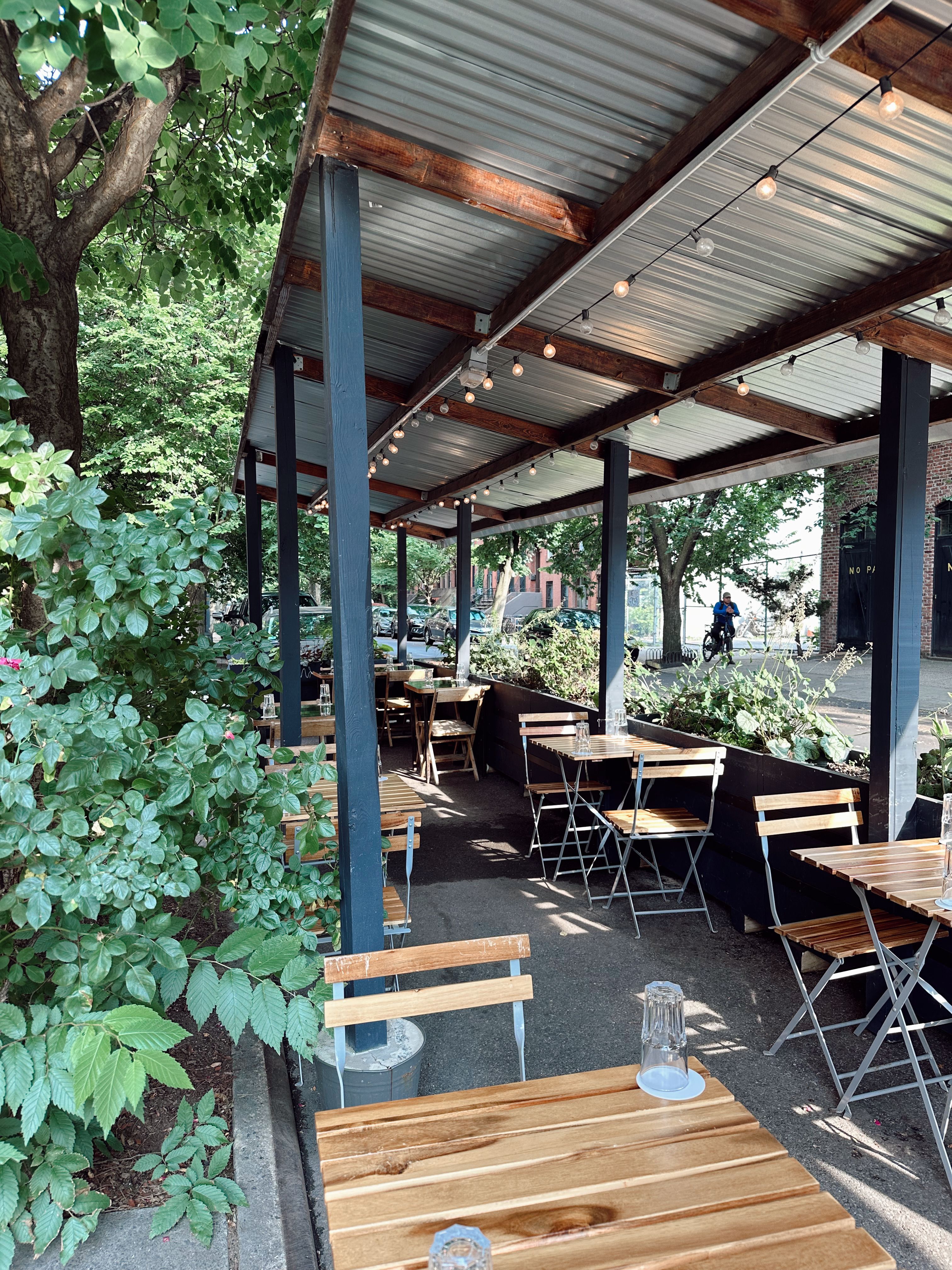 Freestanding outdoor string light poles with string lights strung between them on a small budget patio