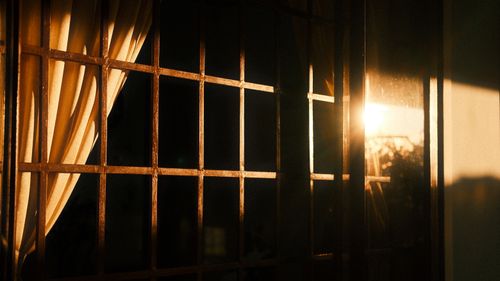 Free Warm sunlight shining through metal window bars and curtain, creating a cozy atmosphere. Stock Photo
