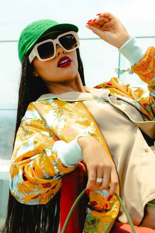 Free Stylish woman in Mexico City posing with sunglasses and cap, showcasing urban fashion. Stock Photo