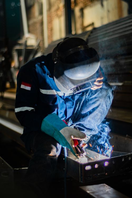 Free A skilled welder working with sparks in an industrial factory environment. Stock Photo