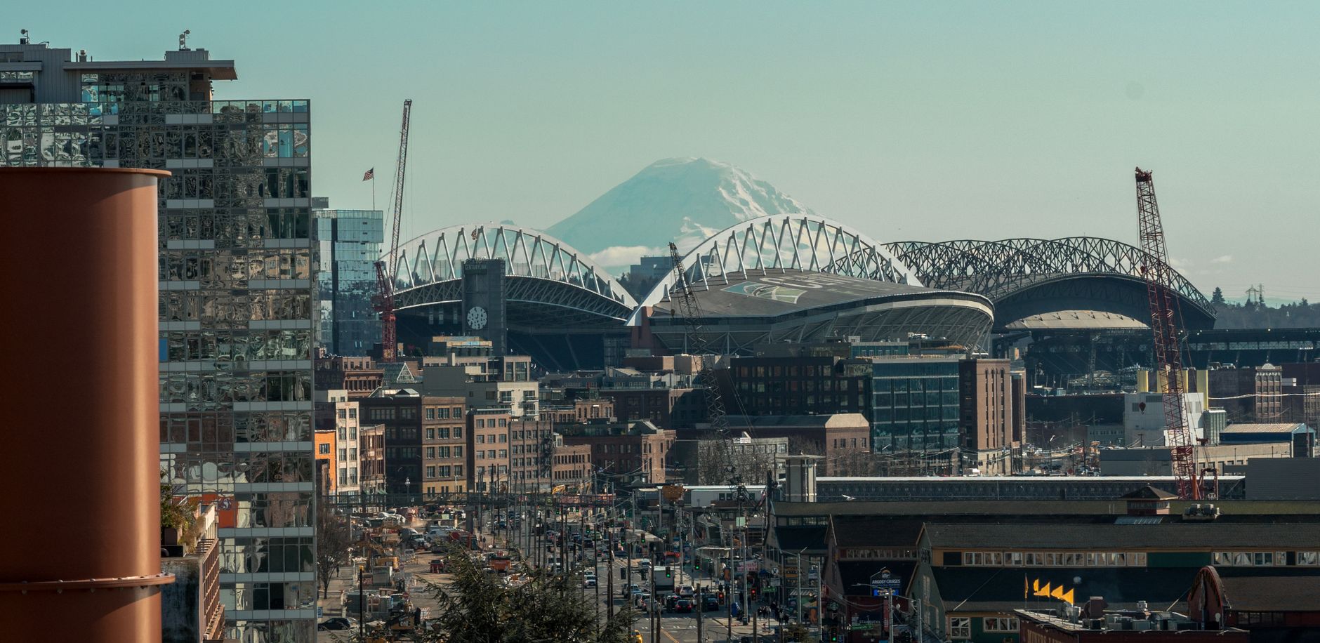 Seattle cityscape featuring Lumen Field and Mount Rainier under a clear sky.