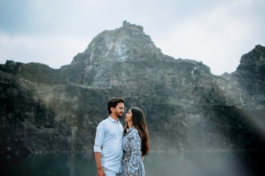 A couple lovingly embraces against a majestic mountain backdrop, capturing a serene romantic moment. - Fotografer Sidoarjo