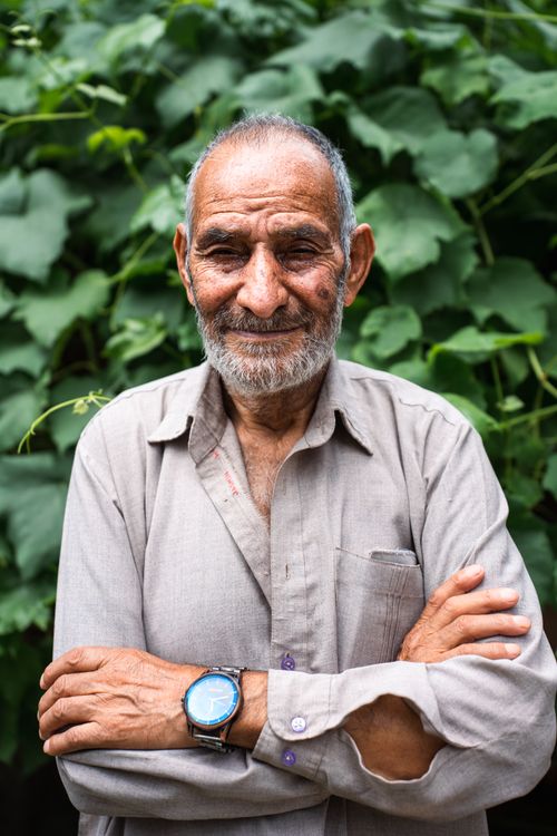 Free Portrait of a smiling elderly man with a beard and mustache, standing outdoors in Srinagar. Stock Photo
