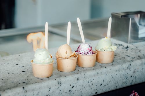 Free Vibrant ice cream scoops in cups with spoons, perfect for dessert lovers in a Mexican ice cream shop. Stock Photo