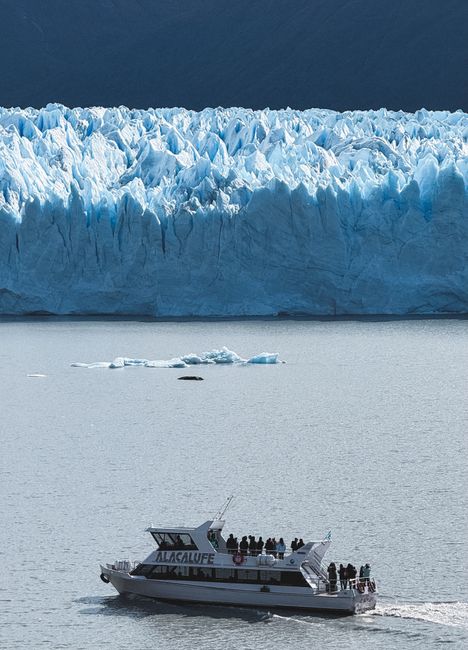 Tourists on a boat admire the stunning Perito Moreno Glacier in Argentina's Santa Cruz province, a majestic winter scene.