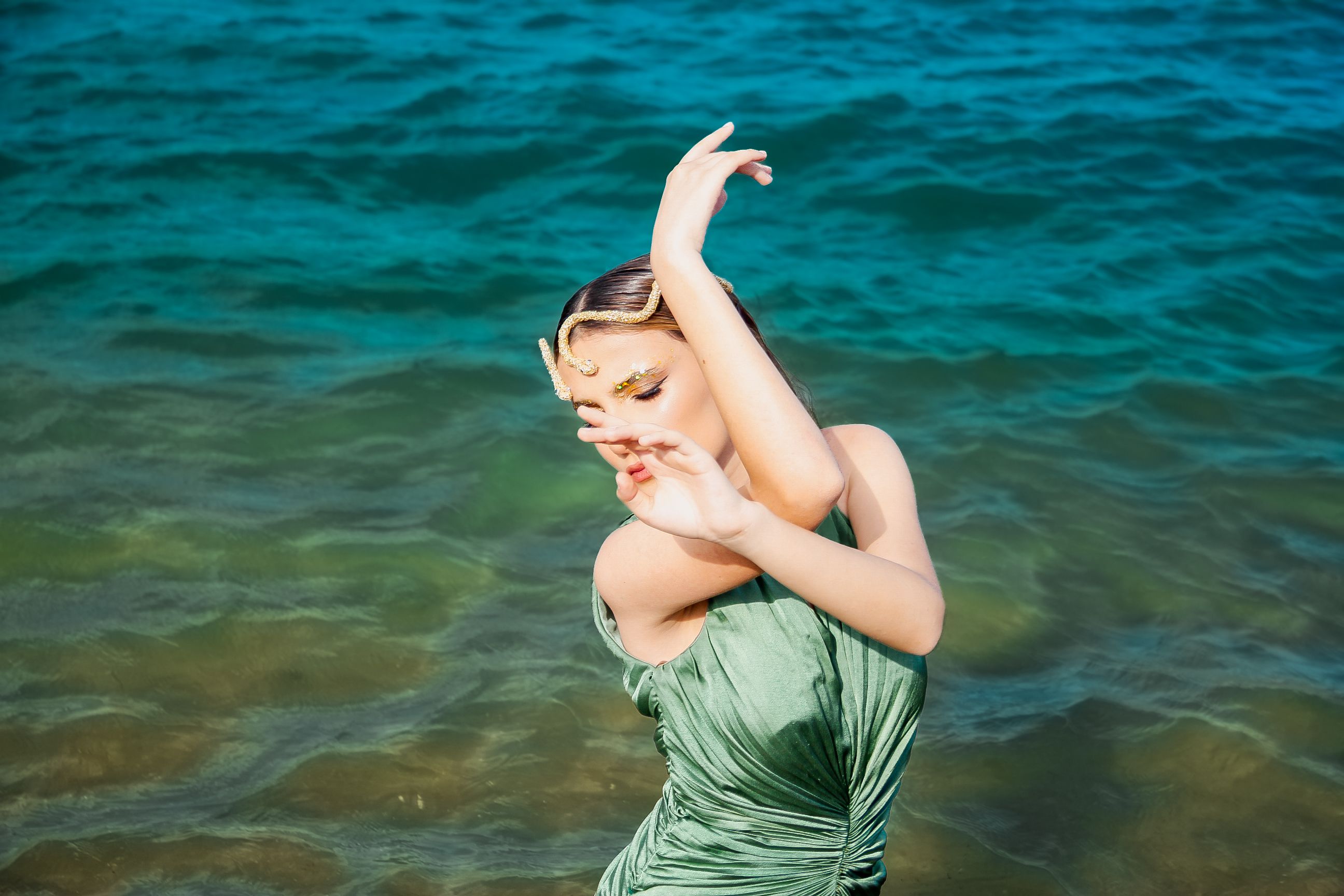 A Woman in a Green Dress Sitting on a Rock on the Shore  Free Stock Photo