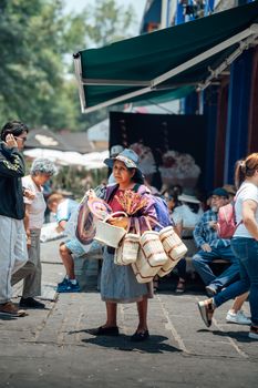 Street vendor in Ciudad de México selling artisan baskets. Captured in a bustling urban setting.