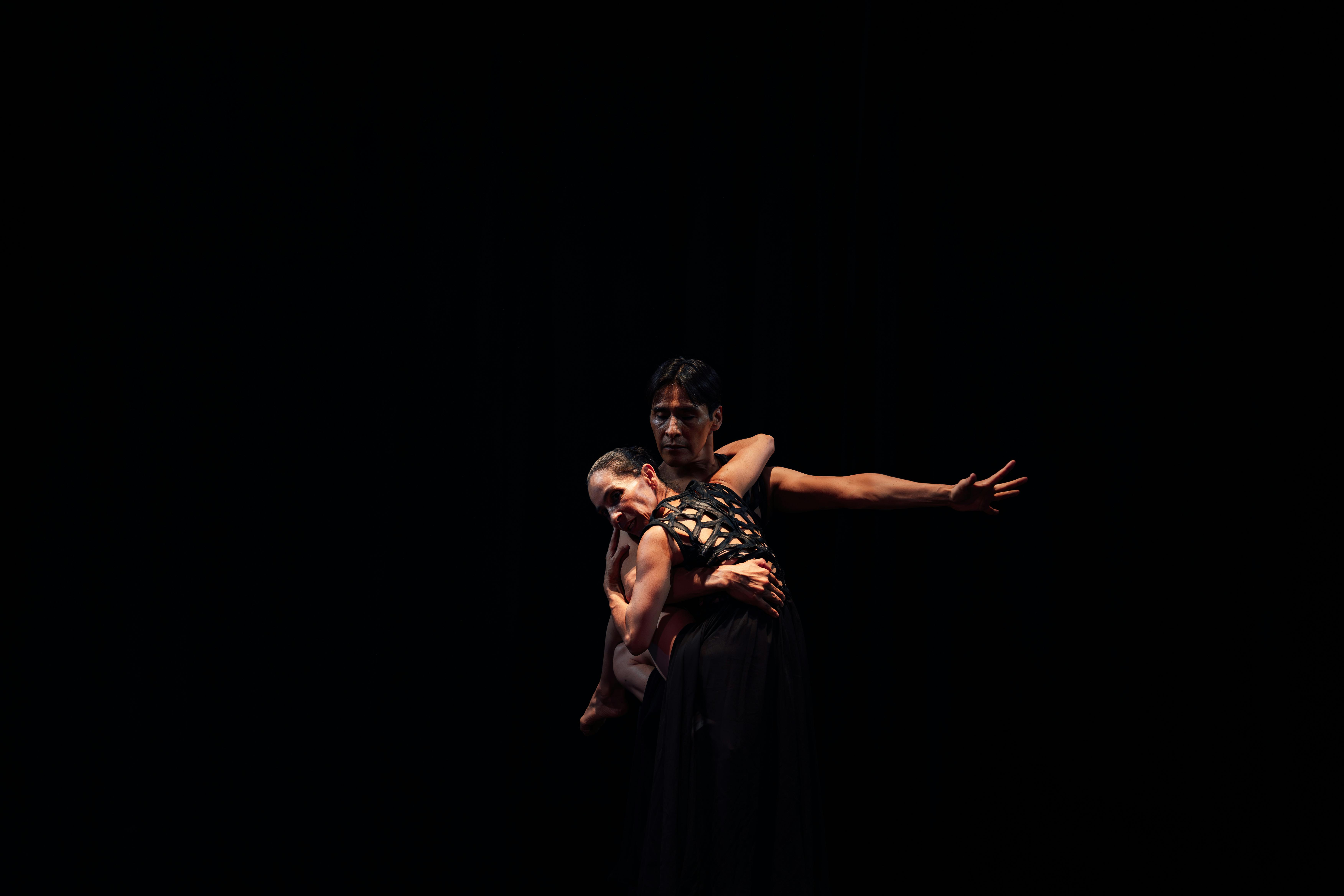 Free A dramatic and elegant dance performance captured in a dark studio setting, showcasing graceful movements. Stock Photo