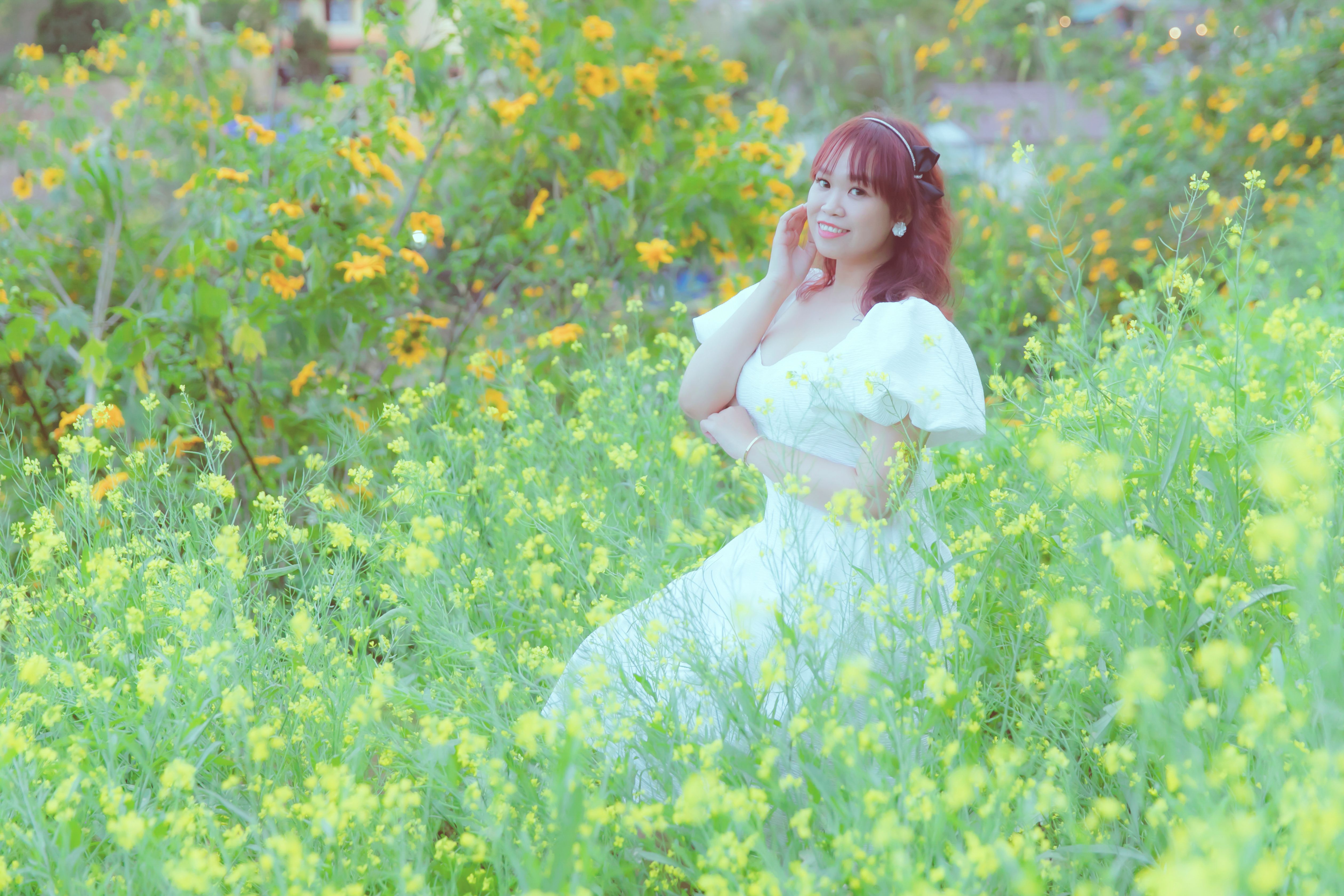 Smiling Woman in White Dress Sitting on Meadow · Free Stock Photo