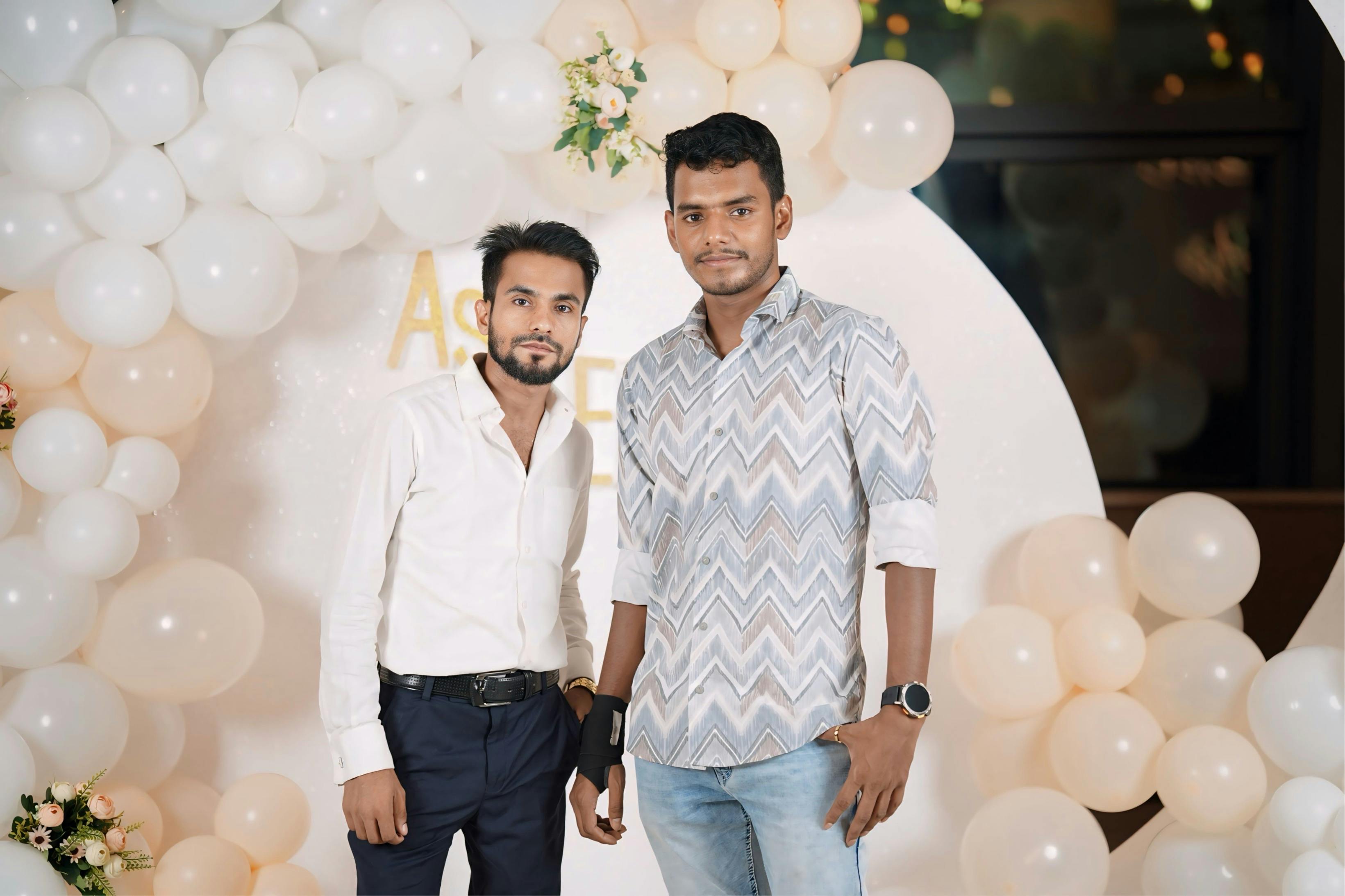 Two young adults at a party with stylish balloon decoration and flowers.