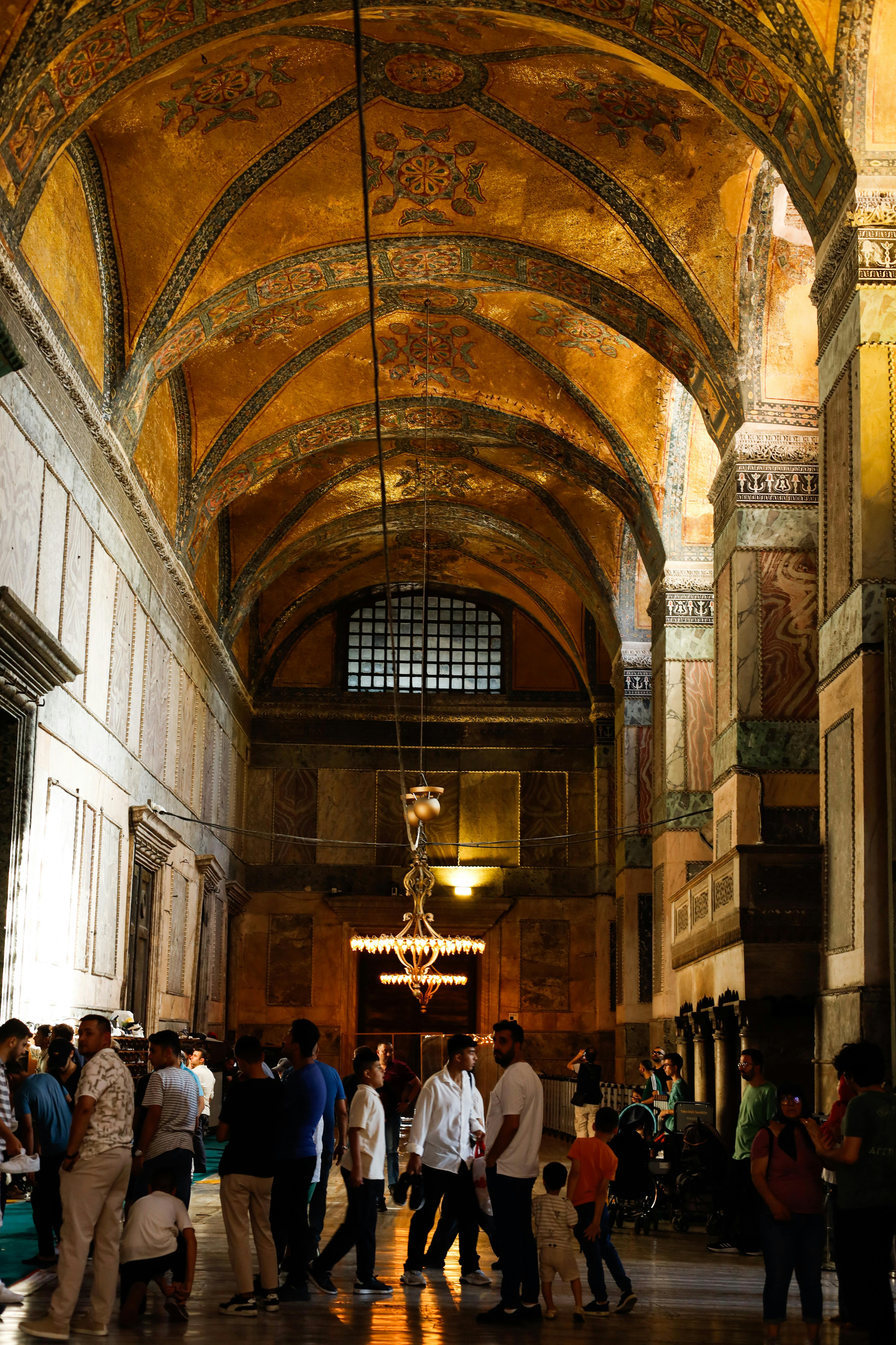 people are walking through a large hall with arched ceilings