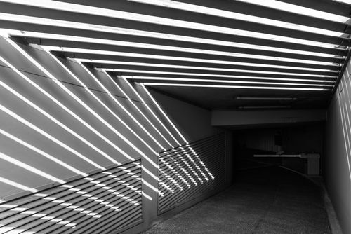 Free Monochrome tunnel scene with dramatic light and shadows creating geometric patterns. Stock Photo